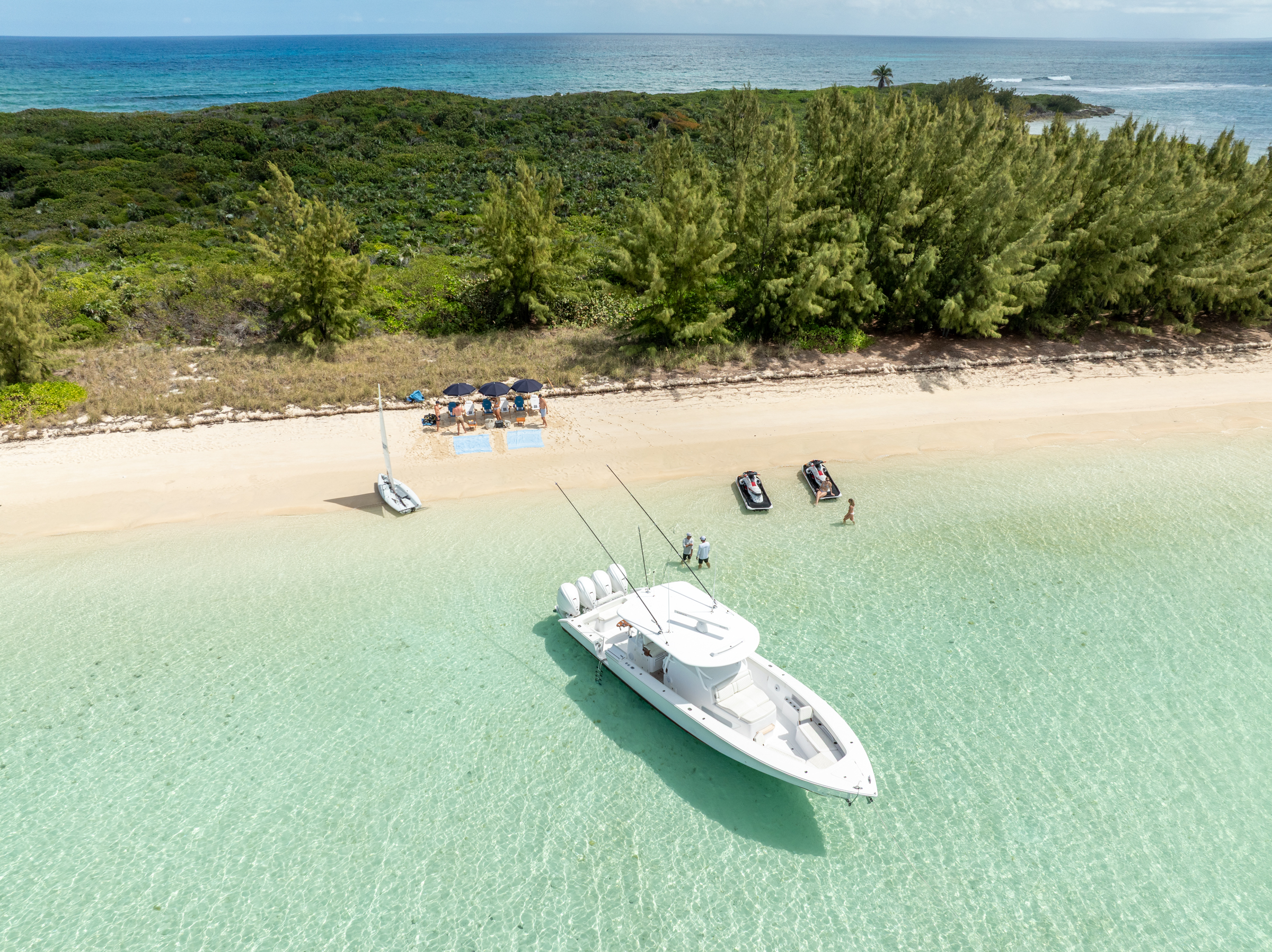 Aerial view of Avalon's tender, jetskis and sailing dinghy landed on a Bahamian beach