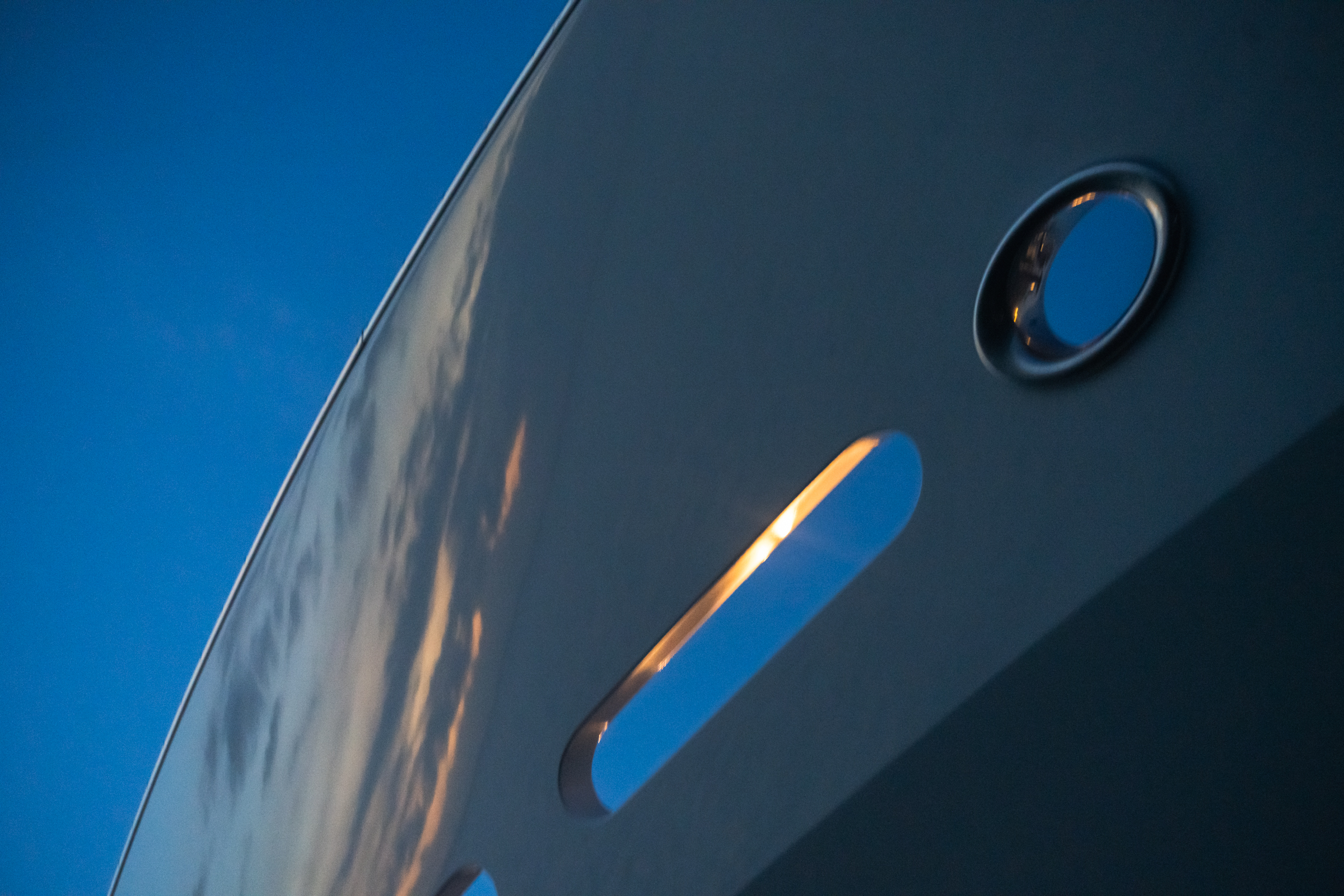 Curved hull and porthole detail of Motor Yacht Avalon at twilight