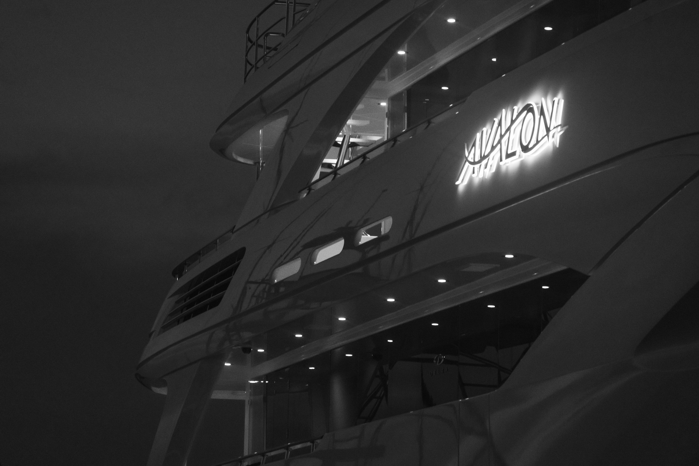 Motor Yacht Avalon's superstructure and AVALON name signage glowing after dark