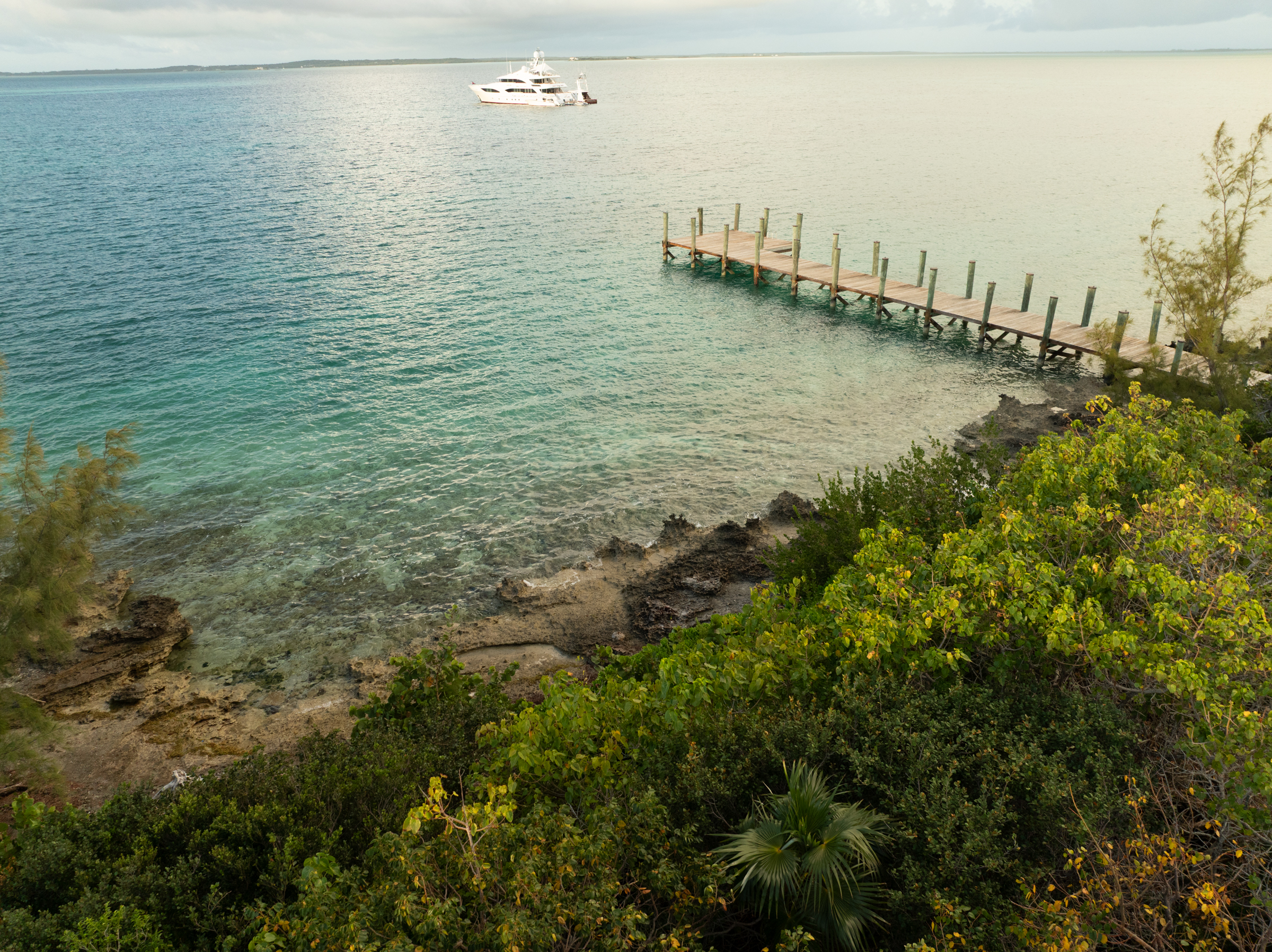 Motor Yacht Avalon anchored off a private Bahamian island with wooden dock